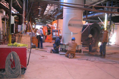 Setting an exhaust&nbsp;stack base section over its anchor bolts.